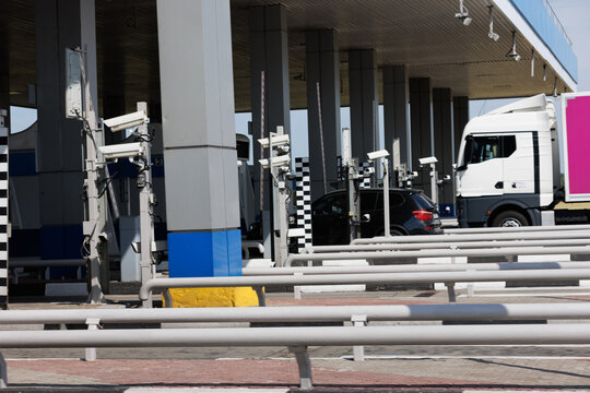 truck and car crossing toll road gates at sunny summer day