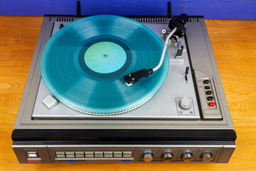 Obraz premium Vintage turntable vinyl record player with turquoise vinyl