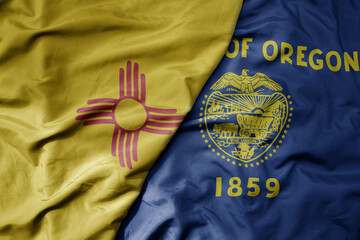 big waving colorful national flag of oregon state and flag of new mexico state .