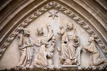 Fototapeta na wymiar Vista del tímpano con la adoración de los Reyes Magos en el arco gótico de entrada a la iglesia de Ujué, monumento nacional en Navarra, España.
