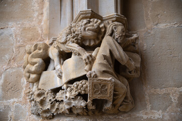 Detalle de un arco gótico con el evangelista san Marcos tallado con el león en la iglesia de Ujué, Navarra, España. - obrazy, fototapety, plakaty
