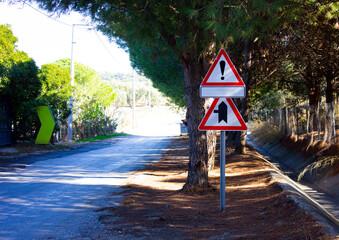Traffic sign in a pathway with asphalt road. Exclamation mark and empty traffic sign for attention...