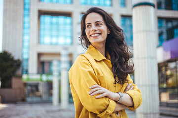 Portrait of a confident young businesswoman standing against an urban background. Portrait of...