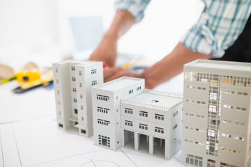 Building models and blueprints are placed on work desks in the construction engineering team...