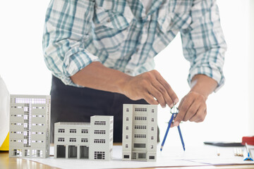 Building models and blueprints are placed on work desks in the construction engineering team...