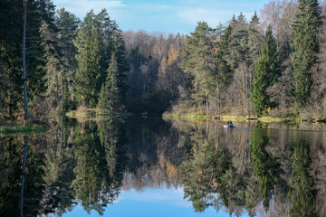 Ņega river in Latvia in autumn. Forest on river shores. Reflection in calm smooth water surface.