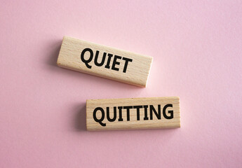 Quiet quitting symbol. Concept word Quiet quitting on wooden blocks. Beautiful pink background....