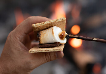 Closeup of S'mores marshmallow, chocolate and crackers by a campfire 