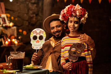 Happy dad smiling at camera together with his daughter while they having dinner party
