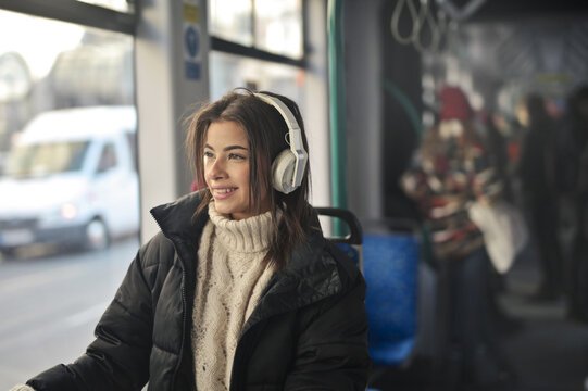 young woman listens to music on the train