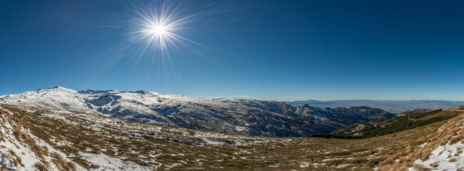 breathtaking panoramic view of the sierra nevada in Granada, Spain, with starry sunshine