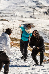 Laughter echoes as this Latino family enjoys a playful snowball fight amidst the stunning snowy landscape of Sierra Nevada, Granada