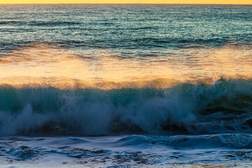 Una fuerte ola al amanecer salpicando agua