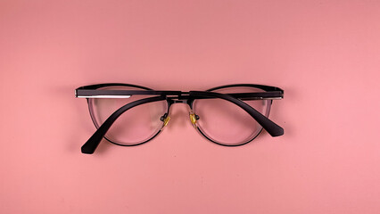 vision glasses lie on a pink background