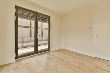 an empty room with wood floor and sliding glass door that leads to the patio area in the room is very clean