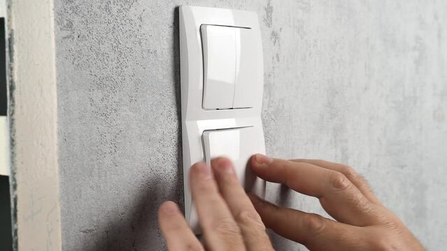 An electrician installs a light switch. Light switch installation close-up.