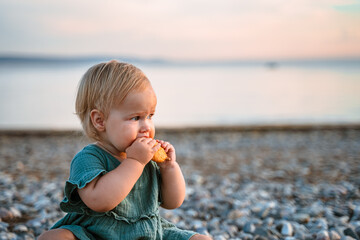 Little baby child on the beach by the sea at sunset,a beautiful concept of childhood and family