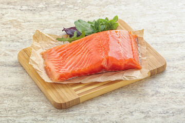 Raw salmon fillet over board