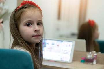 Little girl using her laptop in her room