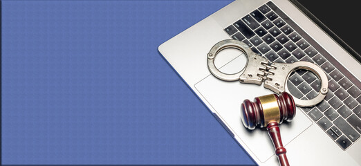Modern Cyber laws concept with gave and handcuff on laptop keyboard