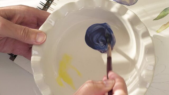 Watercolor painting, colour mixing. Woman draws watercolor sketches, close-up video, flat lay. 