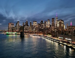 New York Manhattan skyline at night at dusk with Brooklyn Bridge on the Hudson River and World...