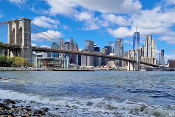New York Manhattan skyline in sunlight with Brooklyn Bridge and Hudson River as well as a view of...