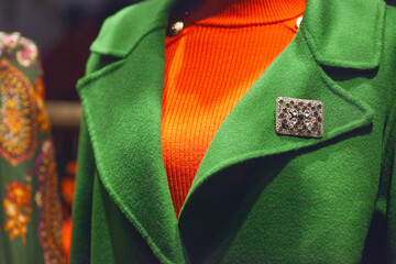 Winter season concept. Green cashmere coat in the window of european fashion boutique. Close up. Outdoor shop