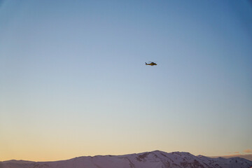 Fototapeta na wymiar Helicopter flying over the Andes mountain range during the sunset.