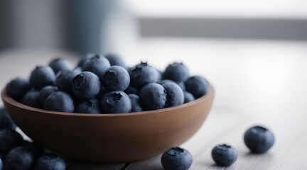 A closeup on a wooden bowl with fresh blueberries on a white wooden table with beautiful smooth defocused background.
