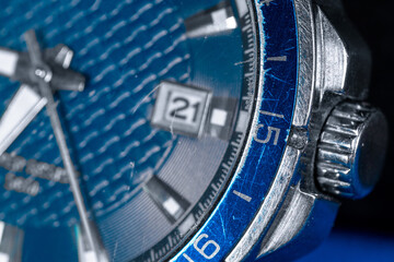 The crown of a wrist watch. Blue dial of a wristwatch close-up. Markings on the dial of a men's watch