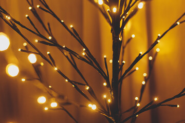 Stylish minimalist glowing tree in evening cozy room. Scandinavian christmas decor, minimal modern...