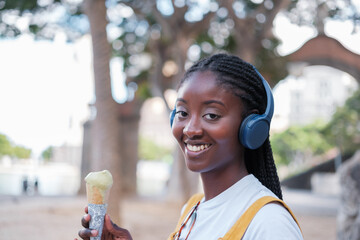 Young woman smiling while carrying an ice cream in her hand. Concept: happy, fun, refresh