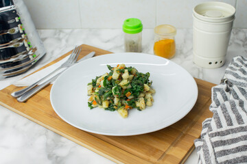 Spinach and potatoes recipe served in a white dish