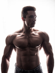 Fototapeta premium Muscles in Motion: Captivating Image of an Attractive, Shirtless Male Bodybuilder. A shirtless man posing for a picture