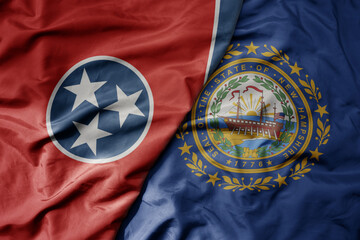big waving colorful national flag of new hampshire state and flag of tennessee state.