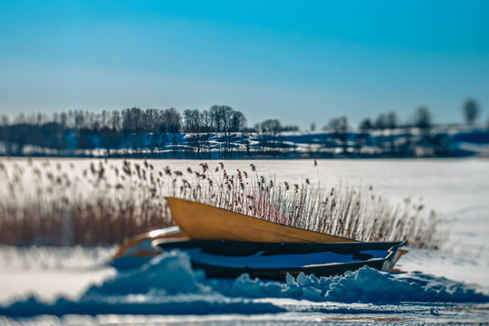During the winter at the lake, a fisherman's boat, metal. Soft selective focus. Artificially created grain for the picture