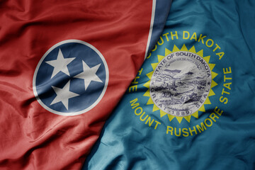 big waving colorful national flag of south dakota state and flag of tennessee state .