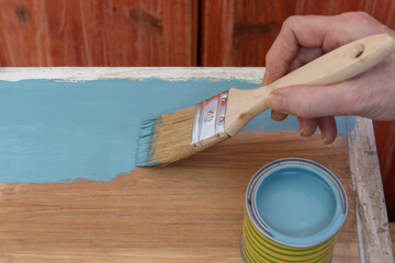Pintando un viejo banco de madera con un pincel