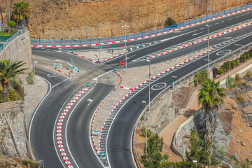 Top view of complex road interchange in mountainous terrain. Transportation and logistics concept....