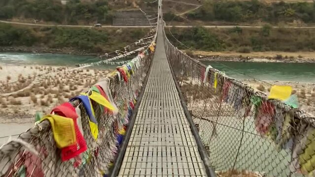Colorful Buddhist prayer flags on the famous tourist attraction Punakha Suspension Bridge on the river next to the Punakha Dzong
