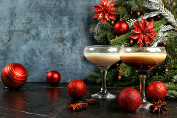Christmas martini with cinnamon, nutmeg and dark chocolate on a dark background with fir branches,...