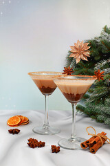 Christmas martini with cinnamon, nutmeg and dark chocolate on a background with fir branches,...