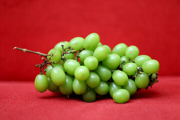 Fresh Green Grapes on red background. healthy fresh grapes concept