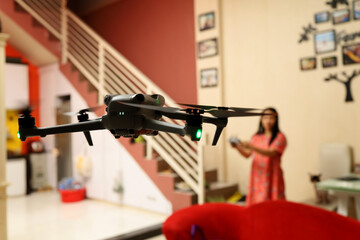beautiful blurred asian woman playing drone indoors. learn to fly a drone indoors.