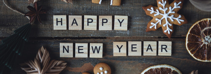 Happy New Year greeting written with wooden blocks . Holidays card on wooden background with...