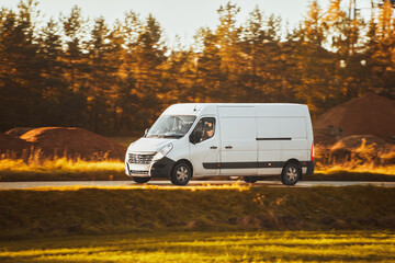On the Delivery Route. Commercial Van Close-Up on the Road. Logistics branding. Commercial van on the road. Final destination shipping truck mock-up. - obrazy, fototapety, plakaty