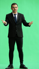 man isolated on a green background shows with his hands a sign of what to expect