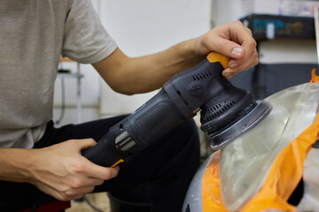 Big headlight cleaning on the car with power buffer machine at service station ,Before and after...