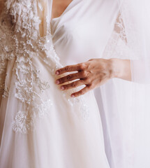 Bride touch beads on your white wedding dress by hand with pearl nails. Bride. Preparations.Wedding.Manicure.